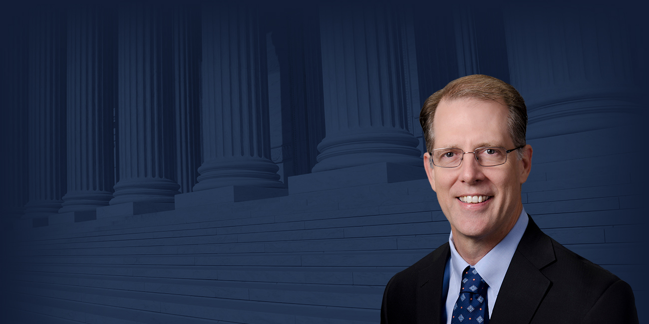 William T. McKinley with a photograph of the Supreme Court of the United States with a blue filter in the background.